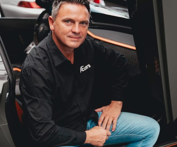 Alexander, zaakvoerder van AEcars, bij een exclusieve sportwagen